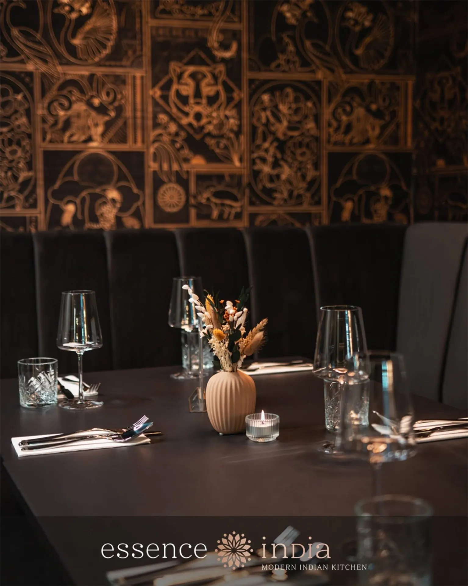 Gedeckter Tisch im essence india – poliertes Besteck, Weingläser und eine einzelne Blumenvase